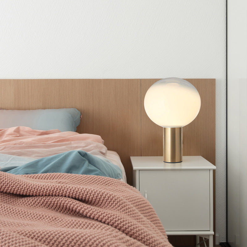 Moderne künstlerische Tischlampe mit schlankem Metallfuß und Globusschirm